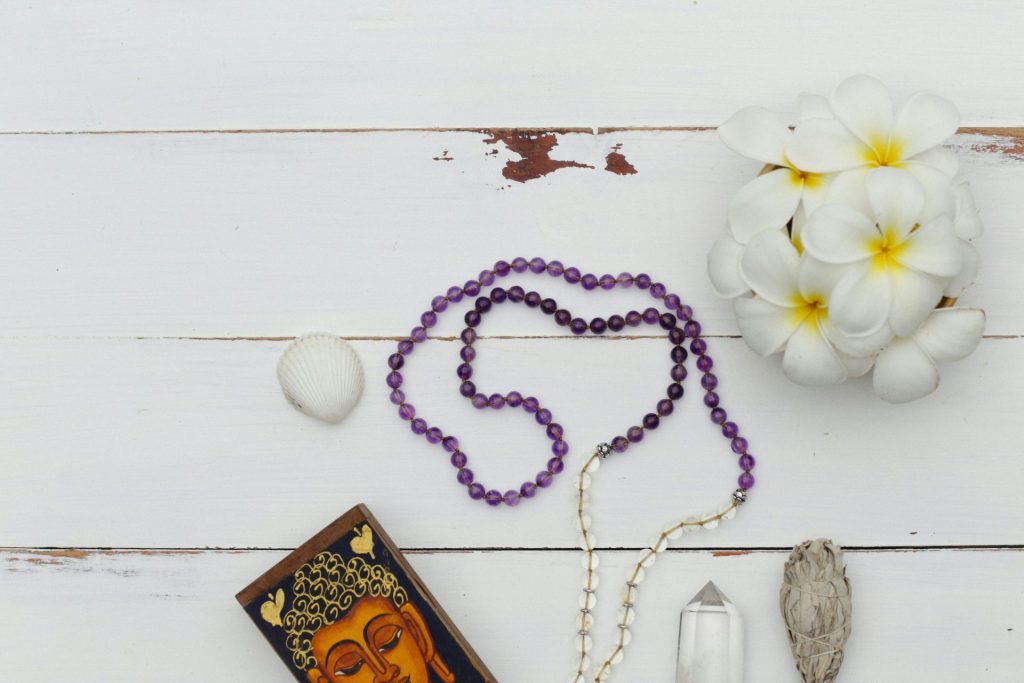 a rosary, a candle, a flower and a picture on a table